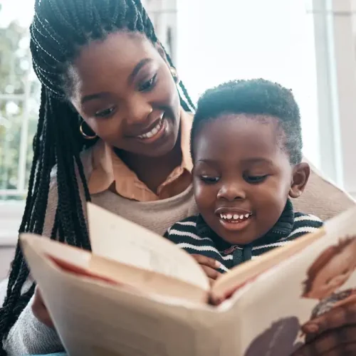 A mother and child sitting together reading a picture book